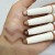Na zdjęciu widoczna jest dłoń, na której wykonano swatche (próbki) kremowych cieni do powiek w kredce marki jane iredale. Na skórze pokazane są cztery różne odcienie – w ciepłej, neutralnej tonacji