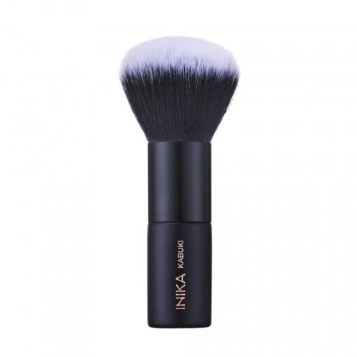 Na zdjęciu widoczny jest pędzel do makijażu typu kabuki marki INIKA Organic. Pędzel ma krótki, czarny trzonek z logo marki i napisem "KABUKI", oraz gęste, zaokrąglone włosie w odcieniach czerni przechodzącej w biel na końcach.
