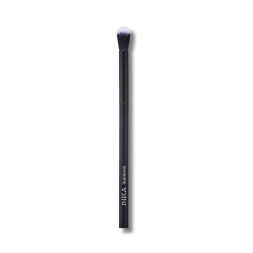 Na zdjęciu znajduje się pędzel do makijażu INIKA Organic Blending Brush. Jest to smukły, czarny pędzel z długą rączką, zakończony miękkim, zaokrąglonym włosiem w odcieniach czerni i bieli. Przeznaczony jest do blendowania cieni na powiekach