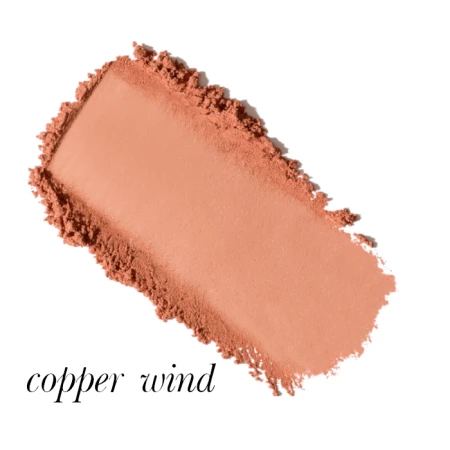 Na zdjęciu widać próbkę odcienia różu Copper Wind – ciepły, brzoskwiniowo-miedziany róż z delikatnym złotym połyskiem; pięknie podkreśla opaloną lub oliwkową cerę.