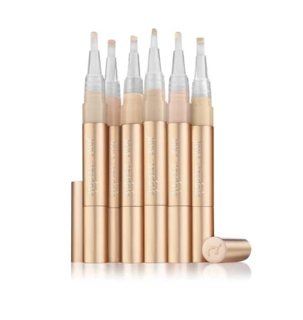 Na zdjęciu znajduje się zestaw korektorów rozświetlających Active Light marki Jane Iredale. Produkty mają eleganckie, złote opakowania w formie pisaka z pędzelkowym aplikatorem. Dostępne są w różnych odcieniach, dopasowanych do karnacji.