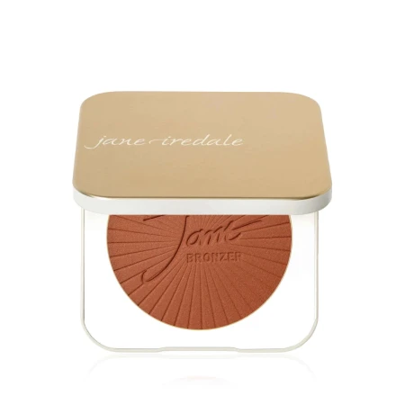 Na zdjęciu jest kompaktowe opakowanie wielokrotnego użytku marki jane iredale.  Mminimalistyczny, elegancki design w kolorze złotym i białym,  napis na froncie: “you make the world more beautiful. Wewnątrz puder.
