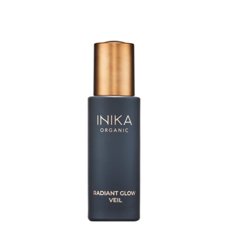 Na zdjęciu znajduje się produkt marki INIKA Organic o nazwie Radiant Glow Veil. elegancka butelka z matowego, ciemnego szkła z metaliczną, złotą nakrętką.