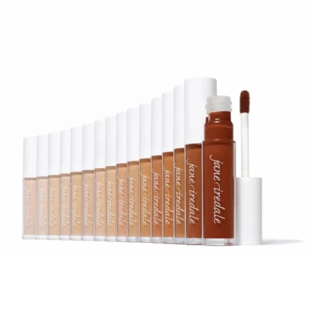 Na zdjęciu jest kolekcja korektorów Jane Iredale Pure Match w płynnej formule z aplikatorem. Produkty ułożone są według gamy kolorystycznej – od bardzo jasnych po ciemne. Opakowania są eleganckie: przezroczyste z białą nakrętką i logo marki.