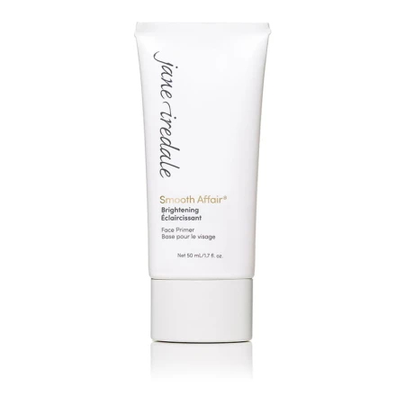 Na zdjęciu znajduje się biała tubka bazy pod makijaż Jane Iredale Smooth Affair Brightening Face Primer. Na niej czarno – złote napisy z nazwą produktu. Produkt rozświetla i wygładza skórę i przygotowuje ją do aplikacji makijażu.