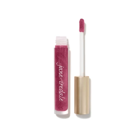 Na zdjęciu znajduje się błyszczyk do ust marki Jane Iredale w odcieniu Candied  rose. Produkt zamknięty jest w eleganckim, przezroczystym opakowaniu z aplikatorem typu gąbeczka i złotą zakrętką. Kolor błyszczyka to połyskujący róż z malinowym tonem