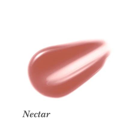 Na zdjęciu widoczny jest błyszczyk do ust Jane Iredale w odcieniu Nectar. Nectar to ciepły, brzoskwiniowy odcień nude z lekkim połyskiem. Kolor ten doskonale komponuje się z opaloną skórą i makijażem w tonacji brązowo-złotej.