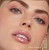 Na zdjęciu widzimy modelkę noszącą błyszczyk do ust Jane Iredale w odcieniu Crystal. Usta modelki są pokryte przezroczystym błyszczykiem, który nadaje im efektowny połysk i lekko wilgotny wygląd.