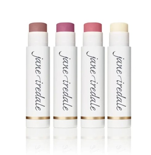 Na zdjęciu widoczne są cztery sztyfty pomadek ochronnych Jane Iredale. Produkty te mają eleganckie, białe opakowania z logo marki i złotym akcentem przy podstawie. Każdy ma inny odcień – od neutralnych beży i różów po klasyczny bezbarwny balsam.
