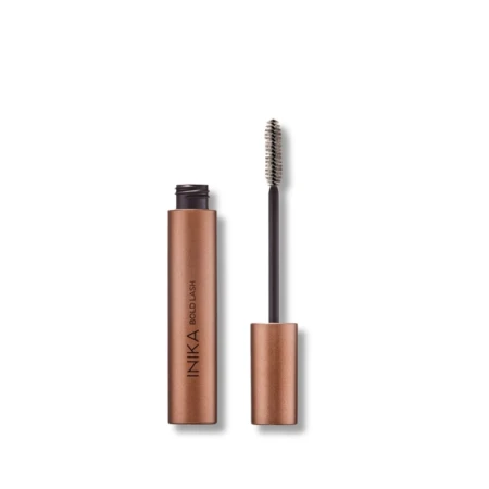 Na zdjęciu znajduje się tusz do rzęs marki INIKA Organic – Bold Lash Mascara w charakterystycznym metalicznym opakowaniu w kolorze miedzianego złota. Produkt został przedstawiony z odkręconą zakrętką, odsłaniając klasyczną szczoteczkę do aplikacji tuszu.