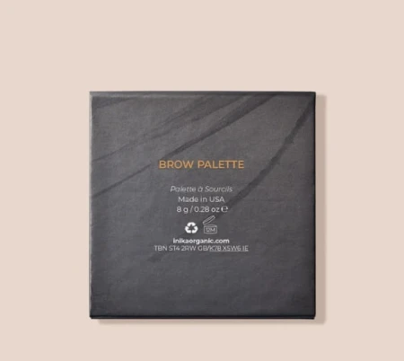 Zdjęcie przedstawia tył opakowania paletki do brwi INIKA Organic – Brow Palette. Opakowanie ma elegancki, minimalistyczny design w odcieniach czerni z delikatnym, marmurkowym wzorem i złotymi napisami.