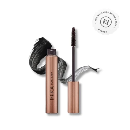 Na zdjęciu widoczna jest maskara INIKA Organic Long Lash Mascara w eleganckim, miedzianym opakowaniu. Produkt został zaprezentowany z odsłoniętą szczoteczką oraz efektownym rozmazaniem tuszu, które podkreśla intensywną czerń