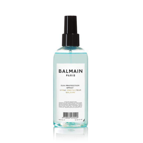 Balmain Paris Sun Protection Spray w przezroczystej, turkusowej butelce z czarnym atomizerem. Stylowy, minimalistyczny design z czarnym napisem.