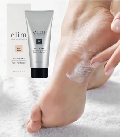Zdjęcie przedstawia aplikację kremu Elim MediHeel Foot Perfector na piętę stopy. W tle widoczna jest tubka produktu oraz jego opakowanie. Kompozycja podkreśla pielęgnacyjne właściwości kremu do suchych i popękanych stóp.
