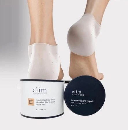 Stopy w żelowych skarpetkach Elim MEDIHEEL na popękane pięty. Przed nimi dwa produkty: biały pojemnik z balsamem do pięt i czarny słoik Intense Night Repair. Jasne tło, estetyczna prezentacja pielęgnacji stóp.