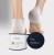 Stopy w żelowych skarpetkach Elim MEDIHEEL na popękane pięty. Przed nimi dwa produkty: biały pojemnik z balsamem do pięt i czarny słoik Intense Night Repair. Jasne tło, estetyczna prezentacja pielęgnacji stóp.