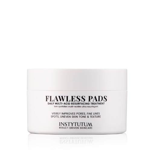 Na zdjęciu znajduje się elegancki biały pojemnik z produktem kosmetycznym Instytutum Flawless Pads. Opakowanie ma minimalistyczny design z czarnym napisem. Produkt przeznaczony jest do codziennego złuszczania skóry.