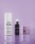 Trzy produkty Instytutum na fioletowym tle: Retinol Toner w białej butelce, serum w ciemnofioletowym opakowaniu z pompką i krem Firm Magic w fioletowym słoiczku. Powierzchnia z lekkim odbiciem i kroplami wody.