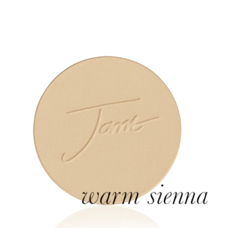Okrągły, prasowany puder do twarzy marki Jane Iredale w odcieniu Warm Sienna: średni ciepły beż z wyraźnie złocistym odcieniem z wytłoczonym logo Jane Iredale