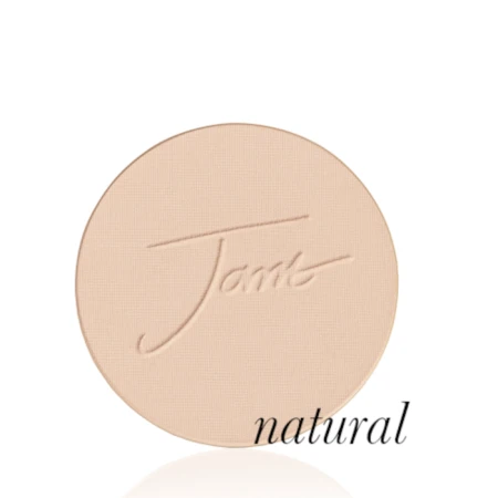 Okrągły, prasowany puder do twarzy marki Jane Iredale w odcieniu Natural: jasny beż z delikatnie złocistym, neutralnym podtonem z wytłoczonym logo Jane Iredale.
