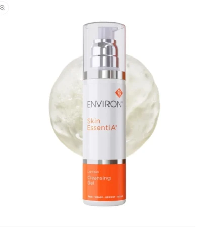 Biała butelka z pompką ENVIRON Cleansing Gel, z biało-pomarańczową etykietą i logo Environ, na tle próbki bezbarwnego żelu.