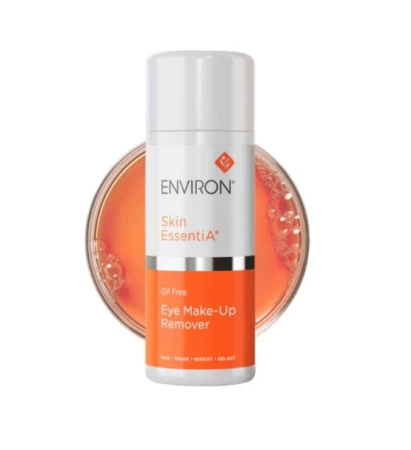 - Biała butelka z pompką ENVIRON Eye Make-up Remover z biało-pomarańczową etykietą i logo Environ, na tle próbki tego płynu w kolorze pomarańczowym.