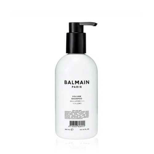 Biała butelka z czarną pompką zawierająca szampon nadający objętość Balmain Paris Volume Shampoo. Minimalistyczny design z czarnym napisem i etykietą. Pojemność 300 ml, przeznaczony do cienkich i delikatnych włosów.