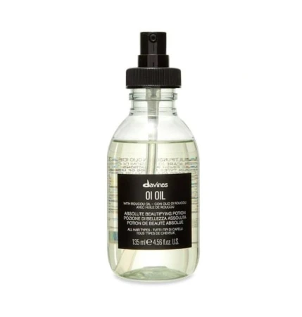 Butelka Davines OI Oil – Absolute Beautifying Potion o pojemności 135 ml. Przezroczyste opakowanie z czarną pompką i czarną etykietą zawiera lekkie, złociste serum do włosów z olejkiem roucou, przeznaczone do wszystkich rodzajów włosów.