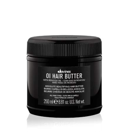 Czarny słoik Davines OI Hair Butter o pojemności 250 ml z czarną zakrętką. Na etykiecie białe napisy informujące o produkcie do pielęgnacji włosów z olejem roucou. Produkt do wszystkich rodzajów włosów. Tło białe z delikatnym cieniem pod spodem.