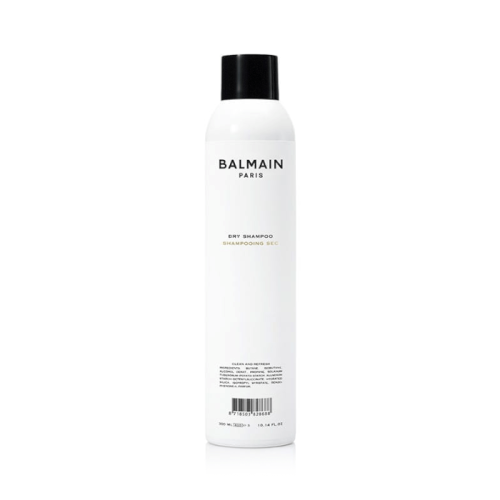Biała butelka z czarną nakrętką zawierająca suchy szampon marki Balmain Paris o pojemności 300 ml. Minimalistyczny design – czarne napisy na białym tle, w tym logo i opis produktu „Dry Shampoo”.