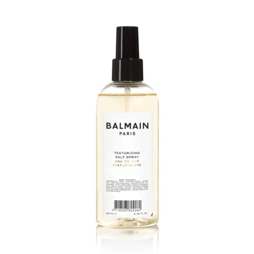 Balmain Paris Texturizing Salt Spray w przezroczystej, lekko żółtawej butelce z czarnym atomizerem. Minimalistyczna etykieta z czarnym napisem.