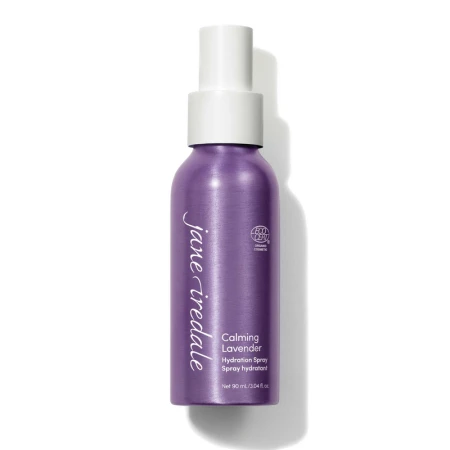 Na zdjęciu znajduje się elegancka, fioletowa butelka z białym atomizerem wody Jane Iredale Lavender Hydration Spray o pojemności 90 ml. Produkt posiada oznaczenie ECOCERT co potwierdza jego organiczne i naturalne pochodzenie składników.