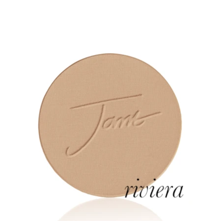 Okrągły, prasowany puder do twarzy marki Jane Iredale w odcieniu Riviera: średni do ciemniejszego beż z ciepłym, złocisto-brązowym podtonem z wytłoczonym logo Jane Iredale.