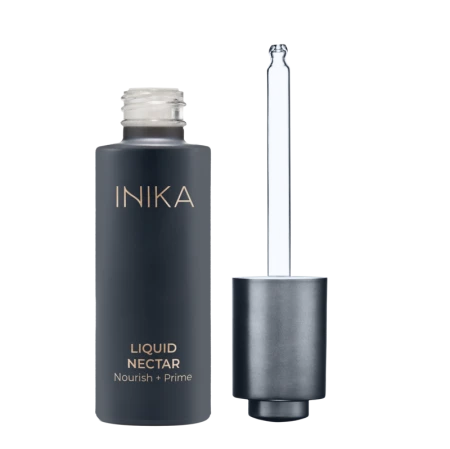 Na zdjęciu widoczna jest butelka produktu INIKA Organic – Liquid Nectar Nourish + Prime. Opakowanie utrzymane jest w eleganckiej, matowej czerni z minimalistycznym, złotym napisem. Buteleczka wyposażona jest w pipetę z metalicznym wykończeniem
