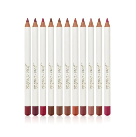 Na zdjęciu zestaw kredek do ust Jane Iredale. Każda kredka ma elegancki, biały korpus z logo marki oraz kolorową końcówkę odpowiadającą odcieniowi kredki. Kolory obejmują:  odcienie czerwieni i bordo, klasyczne róże, brązy i ciepłe nude.