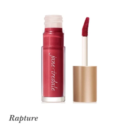Na zdjęciu znajduje się błyszczyk do ust Jane Iredale w odcieniu Rapture. Jest to matowy, głęboki czerwony kolor (matte deep red), który dodaje ustom intensywności i elegancji. Błyszczyk zamknięty jest w estetycznym, przezroczystym opakowaniu