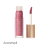 Na zdjęciu przedstawiony jest błyszczyk do ust Jane Iredale w odcieniu Lovestruck. Produkt ma eleganckie, przezroczyste opakowanie z nazwą marki oraz złotą nakrętką, pod którą znajduje się wygodny aplikator z gąbeczką. Lovestruck to chłodny, średni róż