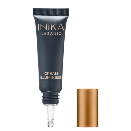 Na zdjęciu jest tubka kosmetyku w ciemnym, eleganckim kolorze z napisem INIKA Organic oraz nazwą produktu Cream Illuminisor. obok jest złota zakrętka, która została umieszczona obok opakowania. Z tubki wystaje aplikator w formie cienkiej końcówki.