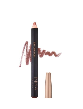 Na zdjęciu widoczna jest kredka do ust marki INIKA Organic – Lip Crayon. Produkt ma elegancki, czarny korpus z delikatnym złotym napisem oraz złotą skuwkę. Obok kredki widnieje próbka koloru w postaci satynowej kreski w naturalnym