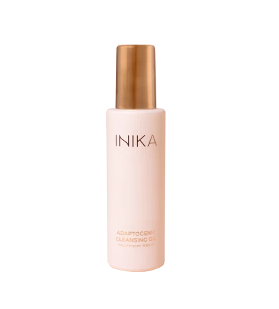 Na zdjęciu widoczny jest INIKA Adaptogenic Cleansing Oil – adaptogenny olejek do oczyszczania twarzy z kompleksem grzybów.  Produkt znajduje się w eleganckiej, matowej butelce w odcieniu pudrowego różu, zakończonej złotym aplikatorem.