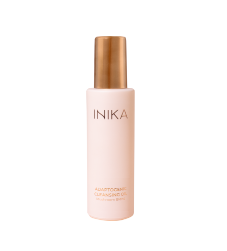 Na zdjęciu widoczny jest INIKA Adaptogenic Cleansing Oil – adaptogenny olejek do oczyszczania twarzy z kompleksem grzybów.  Produkt znajduje się w eleganckiej, matowej butelce w odcieniu pudrowego różu, zakończonej złotym aplikatorem.