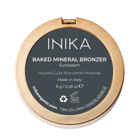 Na zdjęciu znajduje się opakowanie od spodu wypiekanego bronzera mineralnego marki INIKA Organic. Produkt nosi nazwę BAKED MINERAL BRONZER – odcień Sunbeam. Opakowanie ma złoty kolor i elegancki, minimalistyczny design.