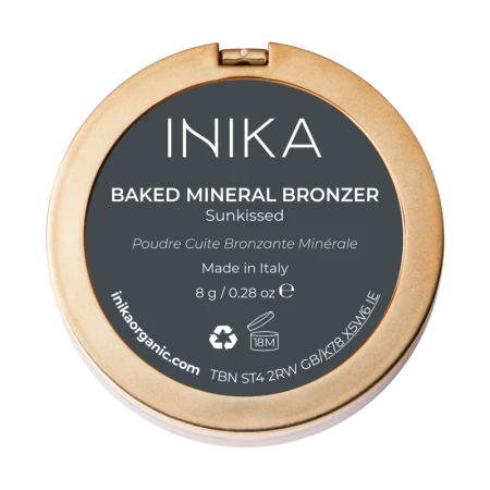 Na zdjęciu znajduje się opakowanie od spodu wypiekanego bronzera mineralnego marki INIKA Organic. Produkt nosi nazwę BAKED MINERAL BRONZER – odcień Sunbeam. Opakowanie ma złoty kolor i elegancki, minimalistyczny design.