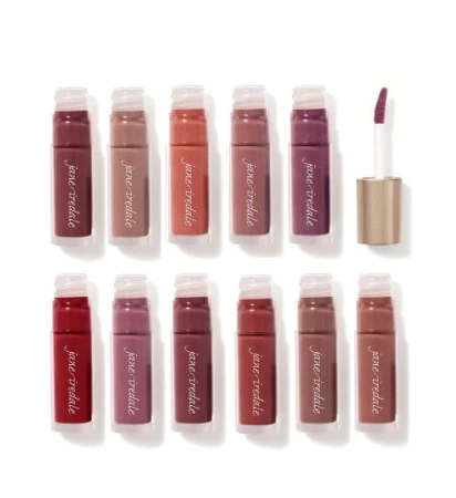 Na zdjęciu przedstawiono kolekcję błyszczyków do ust marki Jane Iredale. Produkty znajdują się w przezroczystych opakowaniach z nazwą marki w białym kolorze. Każde opakowanie ukazuje odcień błyszczyka