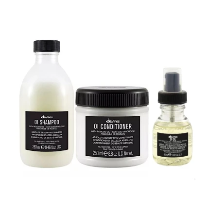 Zestaw kosmetyków do włosów Davines OI: szampon (280 ml), odżywka (250 ml) oraz olejek OI Oil w buteleczce z pompką. Wszystkie produkty w eleganckich opakowaniach z czarnymi etykietami.