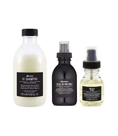 Trzy produkty z serii Davines OI ustawione obok siebie: szampon (260 ml), All In One Milk (mleczko wielofunkcyjne w sprayu) i olejek OI Oil w buteleczce z atomizerem.