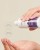 Zbliżenie na damskie dłonie, gdzie jedna dłoń trzyma butelkę ENVIRON Sebu-Tone Clarifier wylewając produkt na drugą dłoń. Obok informacja o zawartych kwasach AHA i BHA.