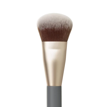 Na zdjęciu jest zbliżenie na włosie pędzla do makijażu marki jane iredale. Ma lekko skośnie ścięte, gęste i puszyste włosie w odcieniach brązu i bieli oraz ciemny trzonek.