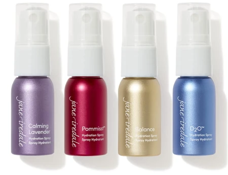 Na zdjęciu widac 4 nawilżające mini wody utrwalające makijaż Jane Iredale: POMMISST, BALANCE, D2 i Lavender. Butelki ułożone są obok siebie.