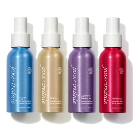 Na zdjęciu widac 4 nawilżające wody utrwalające makijaż Jane Iredale: POMMISST, BALANCE, D2 i Lavender. Butelki ułożone są obok siebie.